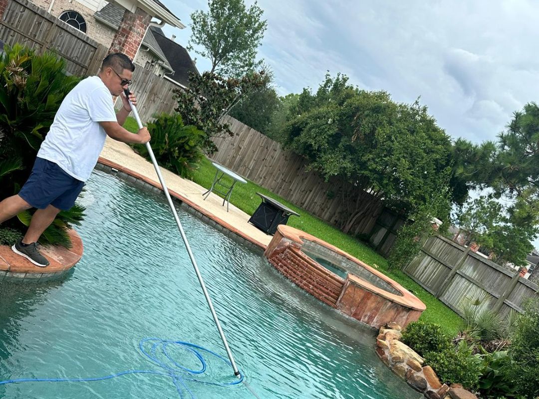 A man cleaning a pool. Pool service near me