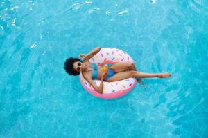 Sugar Land, TX. A woman floating on a pool float shaped like a donut.