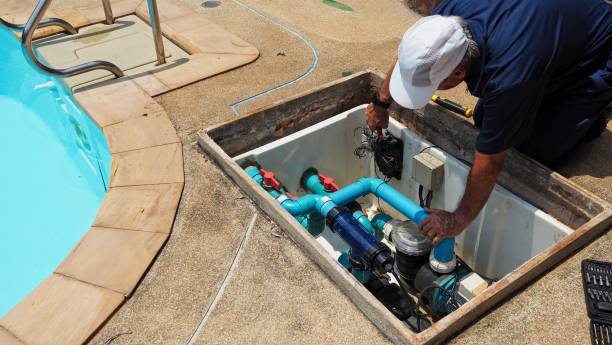 Pool technician repairing damaged pump system beside suburban Missouri City backyard pool